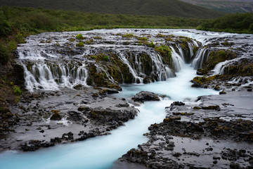 River with a lit small small blue smooth waterfalls