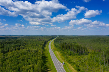 Aerial top view landscape with a country road in the forest at summer