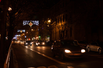 Fototapeta na wymiar Coches transitando de noche entre luces de navidad