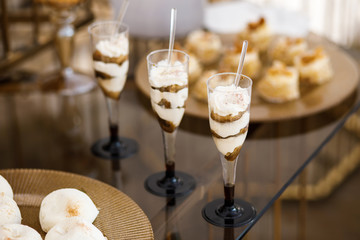 Candy bar at a wedding with tasty sweets and mini cakes.