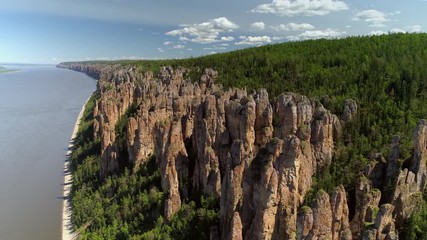 Aerial cinematic natural landscape national park Lena Pillars tall epic rocks vertical stones formation wonder of nature Russia Yakutia Lena river  reserve fabulous national park. Day clouds horizon