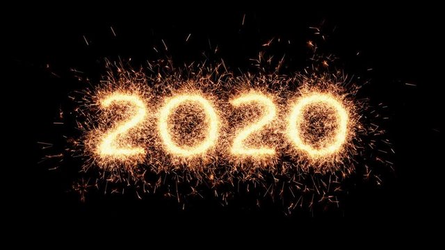 Happy new year. The numbers 2020 made of igniting real sparkler twinkles and sparks - isolated on black background. Design element for any dark background - UHD resolution.
