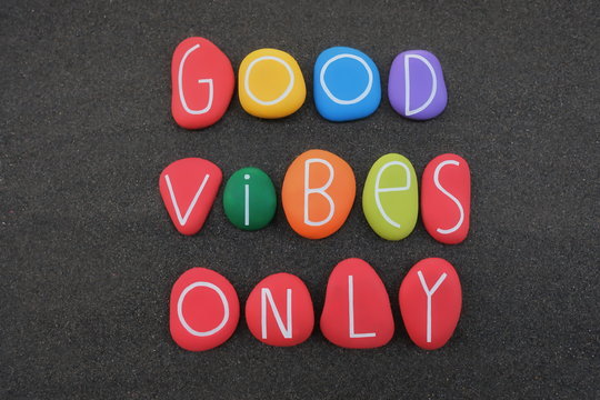 Good Vibes Only, positive phrase for a better life composed with multi colored stone letters over black volcanic sand