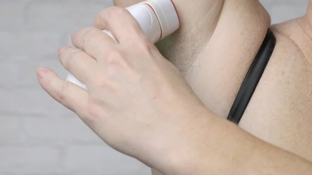 Adult woman uses epilator to remove hair in armpit area. concept of care of Female body.