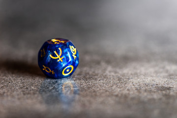 Blue Astrology Dice with symbol of the planet Neptune on grey background