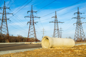 Large concrete pipe for the construction of sewers on the background of high voltage poles