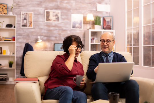 Elderly old couple using modern laptop to chat with their grandson