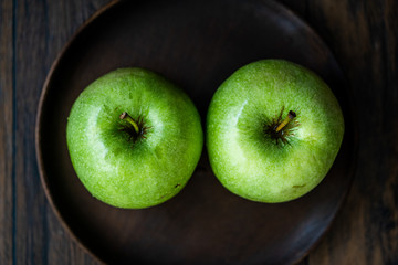 Granny Smith Organic GreenJuicy Apples on Dark Wooden Plate
