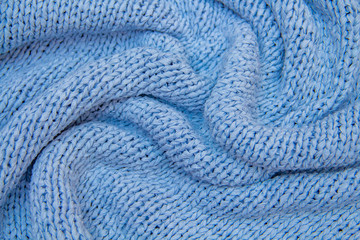textile and texture concept - closeup of woolen crumpled wavy blue fabric