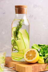 Detox Water Flavored with Sliced Lemon, Cucumber, Rosemary and Fresh Sprigs of Mint. Copy Space