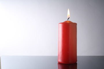 isolated red candle, white background, burning candle on a table 