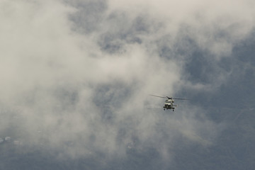 Fototapeta na wymiar military helicopter flying against the background of mountains and clouds