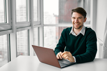 man sitting on sofa and working on laptop