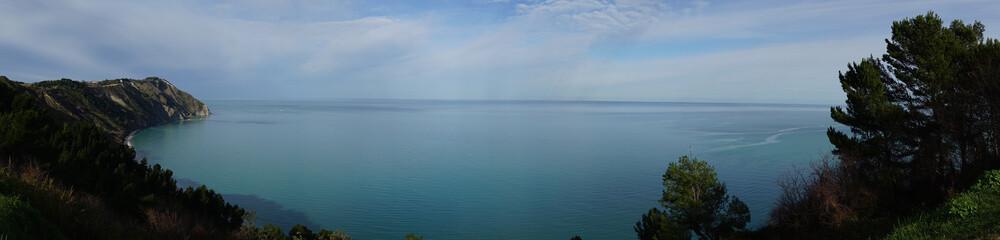 Fototapeta premium Panoramic view of sea between trees at the summer in Ancona - Portonovo area, Italy, Europe, background