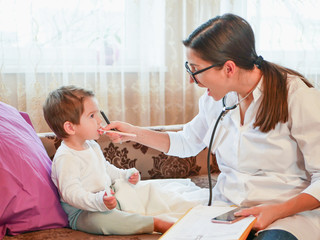 the doctor looks at the redness in the throat. First meeting with a doctor. the doctor is at home....