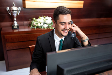 Smiling receptionist tending to hotel needs