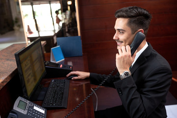 Receptionist holding a telephone handset