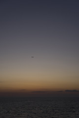 석양 아래 날아가는 비행기