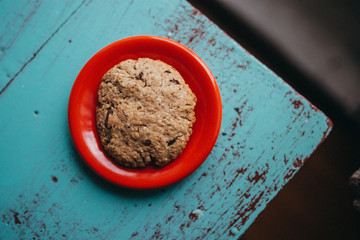 An oatmeal cookie on a red plate
