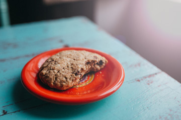 An oatmeal cookie on a red plate