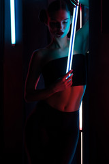 Slim woman with neon lamp
