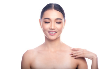 Beautiful Young Asian Woman with Clean Fresh Skin isolate on white background. Spa, Face care, Facial treatment, Beauty and Cosmetics concept. Hand touch shoulder, eye close, big smile.