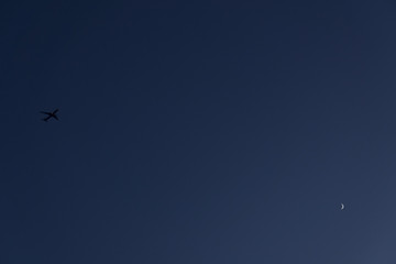 달이 뜬 하늘을 날고 있는 여객기