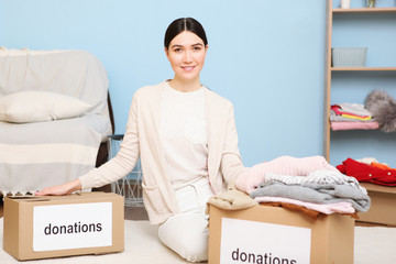 A young girl volunteer collects a box of donations for those in need of an interior room.