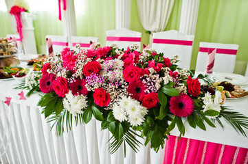 Fototapeta na wymiar Beautiful wedding set decoration in the restaurant. Flowers on table of newlywed.
