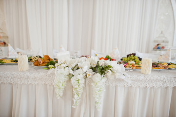 Beautiful wedding set decoration in the restaurant. Flowers on table of newlywed.