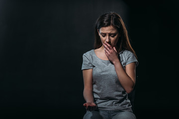 despaired woman going to commit suicide by overdosing medicines isolated on black