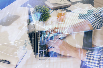 Multi exposure of graph with man typing on computer in office on background. Concept of hard work. Closeup.