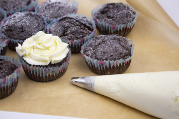 making cupcakes. Chocolate cupcakes and cream syr for toppings. copyspace