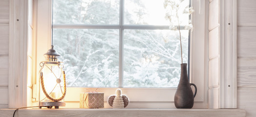Beautiful burning candles and fairy lights on windowsill indoors