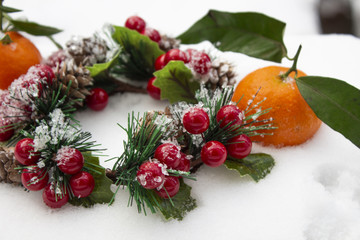 mandarin. tangerines with leaves in the snow. Christmas wreath and tangerines