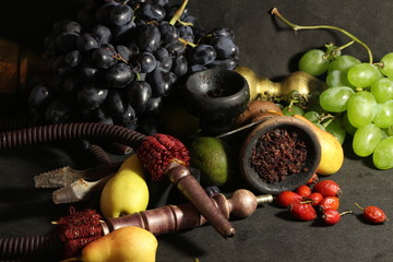 bowl with tobacco for hookah. fruits on a dark background. smoking hookah