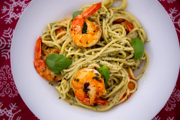 King prawns and pesto sauce with spaghetti on the red background