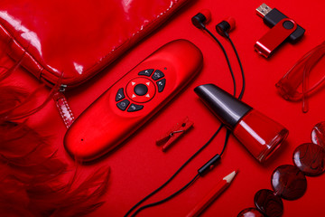 Overhead view of essential beauty items. Woman red accessories, fashion industry, modern life concept, clothes, shoes, gadget, jewelry, cosmetic, other luxury objects on red background.