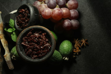 bowl with tobacco for hookah. fruits on a dark background. smoking shiisha
