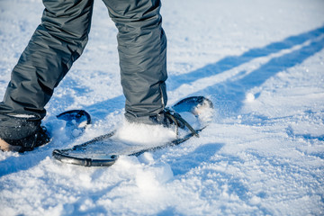 Man walking with snowshoes close-up in Finland.