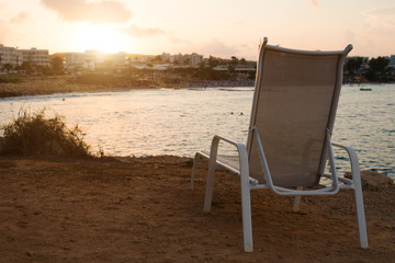 Sunbed in front of Fig Tree Beach in Protaras on sunset.