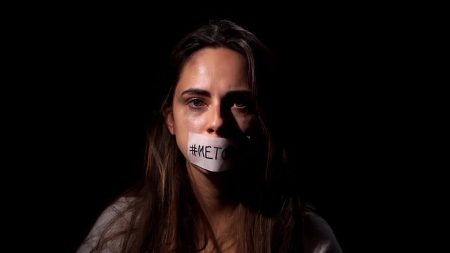 Me too hashtag on taped mouth of woman, support for domestic violence victims. Domestic violence and social problems concept