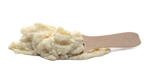 Horseradish sauce in wooden spoon, isolated on white background