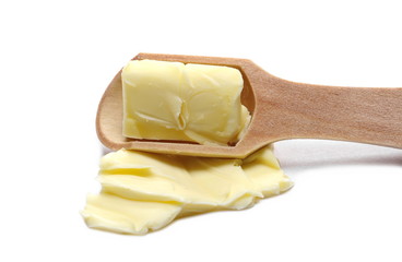 Yellow butter in wooden spoon isolated on white background