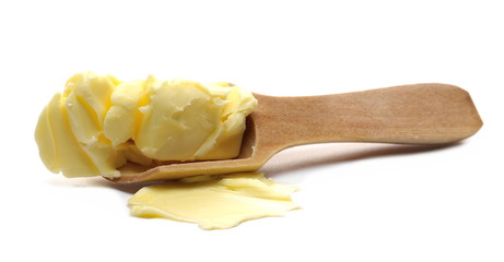 Yellow butter in wooden spoon isolated on white background