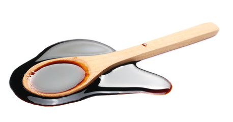 Soy sauce with wooden spoon isolated on white background
