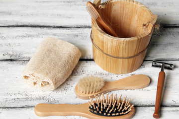 Fototapeta na wymiar Bath set on a white wooden background. Washcloth, razor, brush and comb