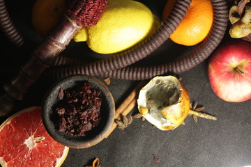 bowl with tobacco for hookah. fruits on a dark background. smoking nargile