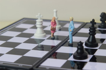 Simple illustration for photo War, Battle or politic situation concept, 2 standing mini figure, man and woman negoitation or debate beyond Small Magnetic Plastic chess
