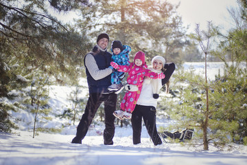 Fototapeta na wymiar Happy and healthy family outside in the snow forest.